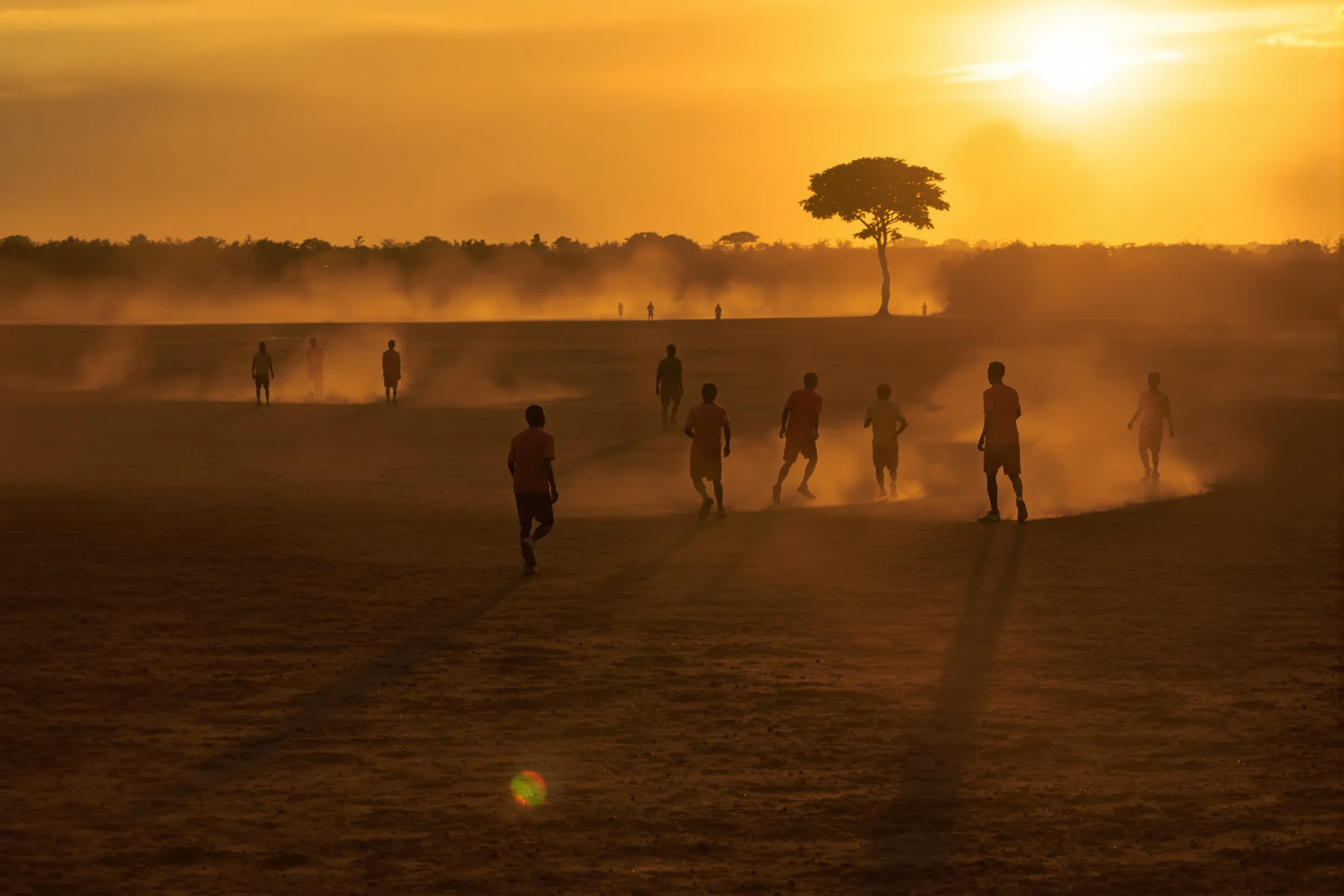 Young African footballers playing at golden hour